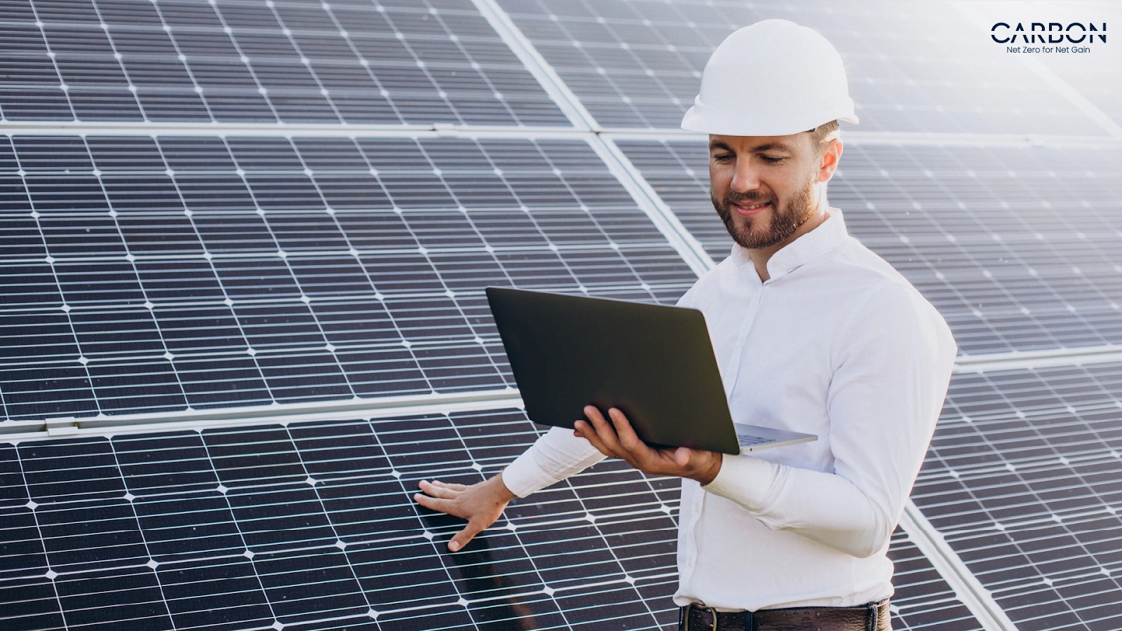 Engineer using laptop to monitor solar panels with O&M predictive analytics for improved performance and efficiency
